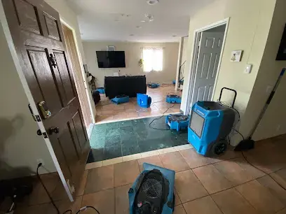 Dehumidifier and air movers set up in a Modesto living room after a water leak