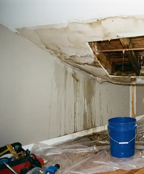 Ceiling opened below a dripping pipe with water stains running down the wall in Modesto