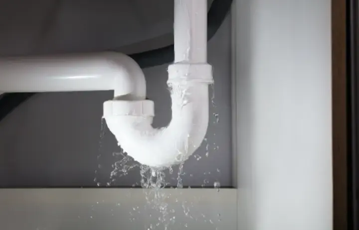 Water dripping from a leaking under-sink pipe in a Modesto kitchen