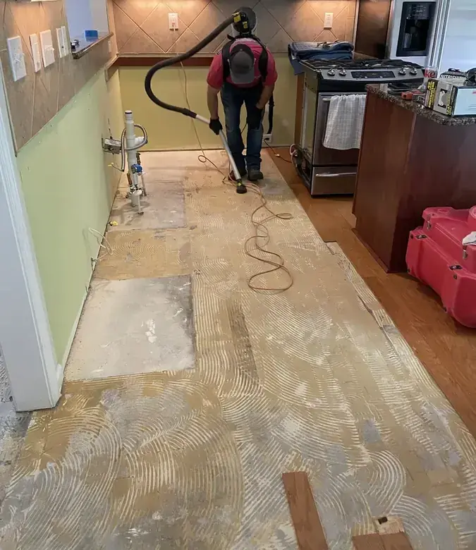Extraction hose clearing water from a Modesto kitchen floor after the flooring came up